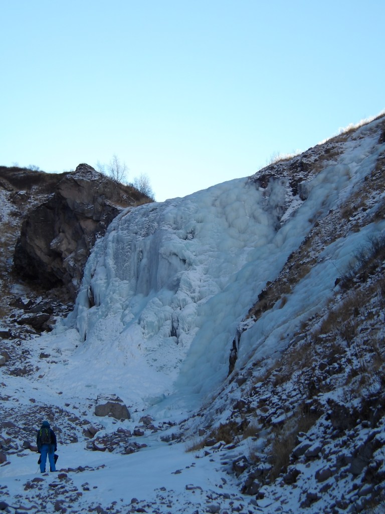 Ice climber on the broad frozen waterfall Perfect View